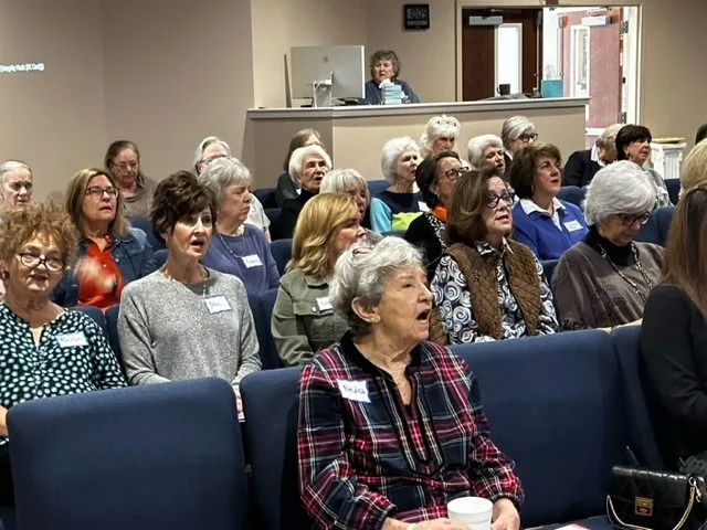 Women of the church gathered around tables for Bible study